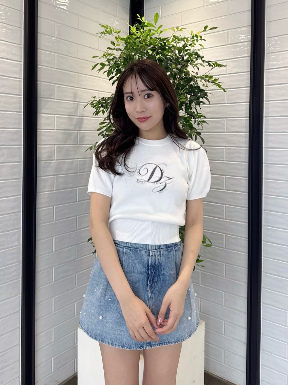 ホワイト系のニット/セーター、ブルー系のデニムパンツ、ホワイト系のブーツを着用したレディースの春コーディネートの8枚目の写真