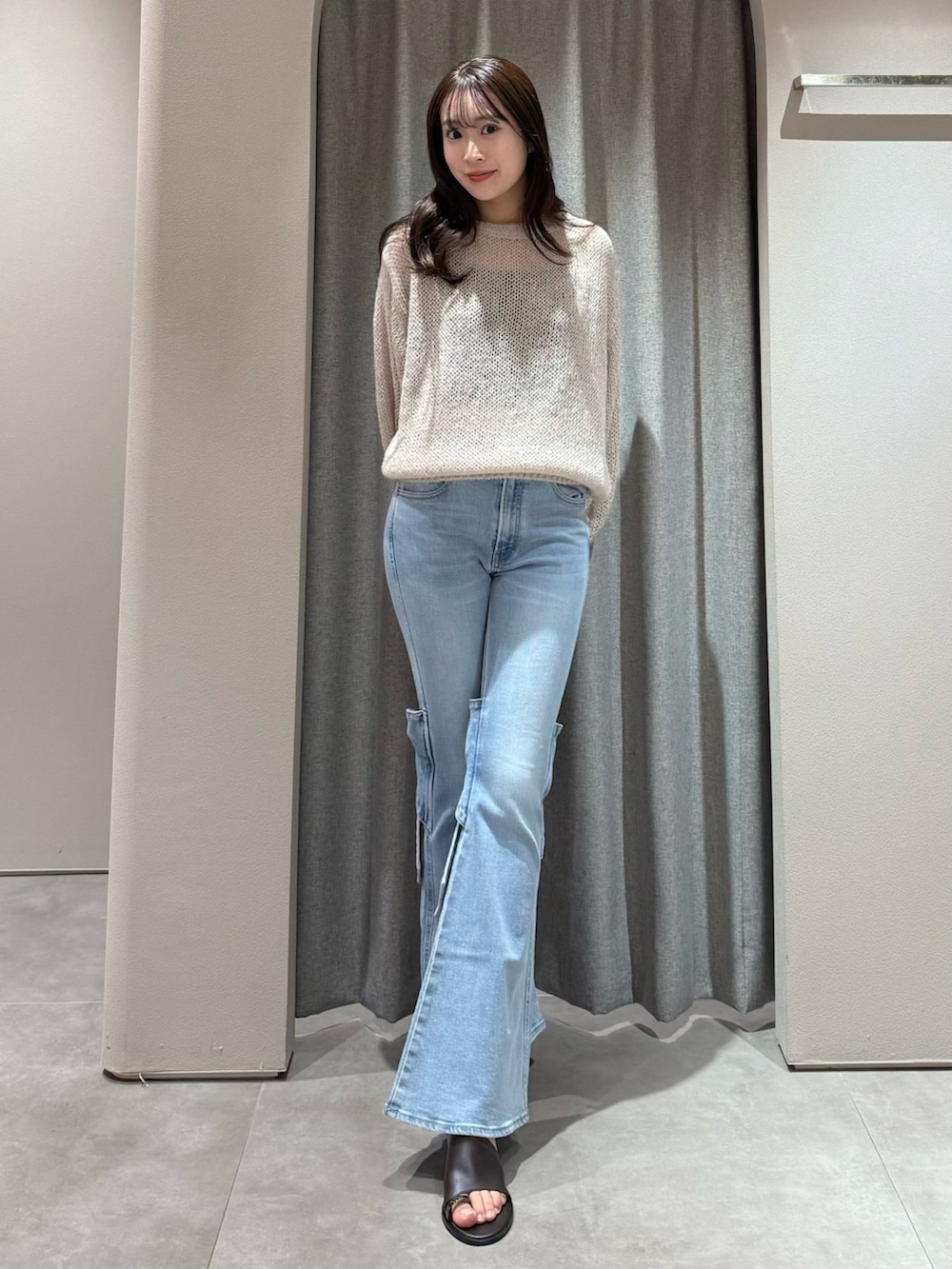 ピンク系のニット/セーター、ブルー系のデニムパンツ、ブラウン系のサンダルを着用したレディースの冬コーディネートの2枚目の写真