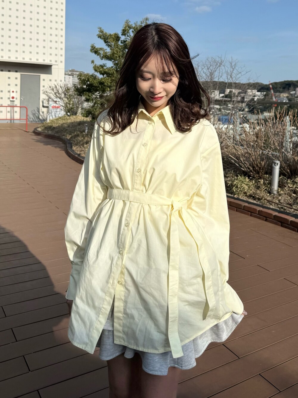 イエロー系のシャツ/ブラウス、グレー系のスカートを着用したレディースの春コーディネートの9枚目の写真