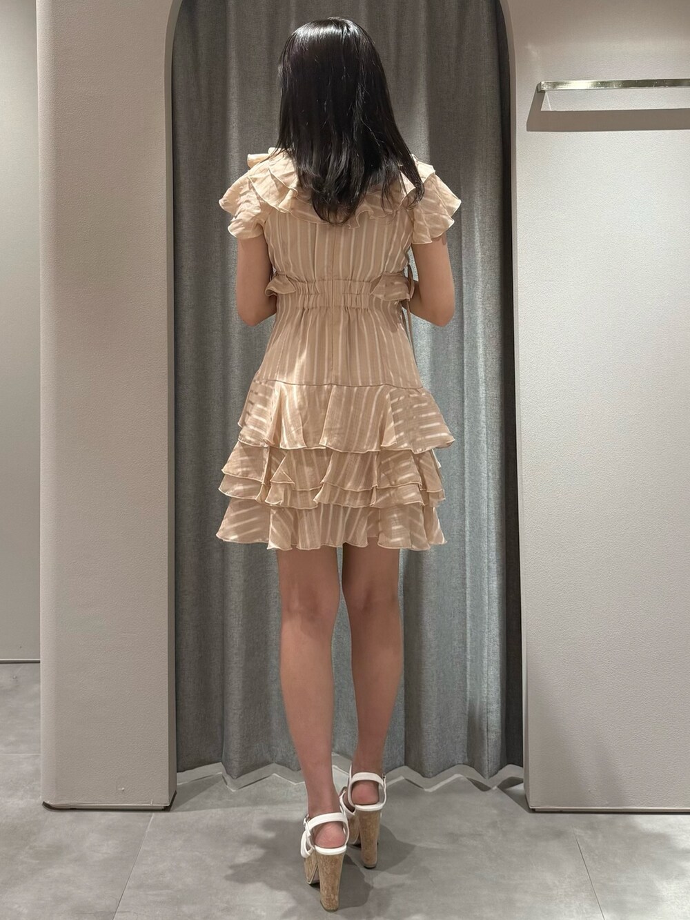 オレンジ系のワンピース、ホワイト系のサンダルを着用したレディースの夏コーディネートの5枚目の写真