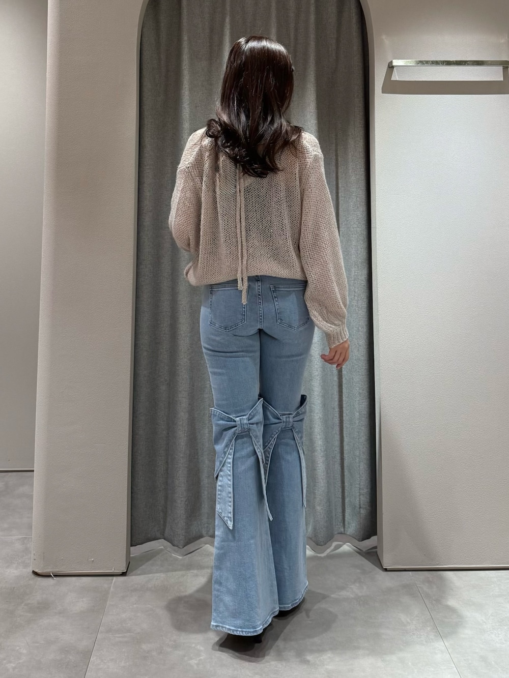 ピンク系のニット/セーター、ブルー系のデニムパンツ、ブラウン系のサンダルを着用したレディースの冬コーディネートの5枚目の写真