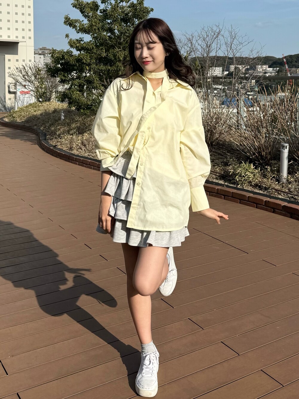 イエロー系のシャツ/ブラウス、グレー系のスカートを着用したレディースの春コーディネートの3枚目の写真