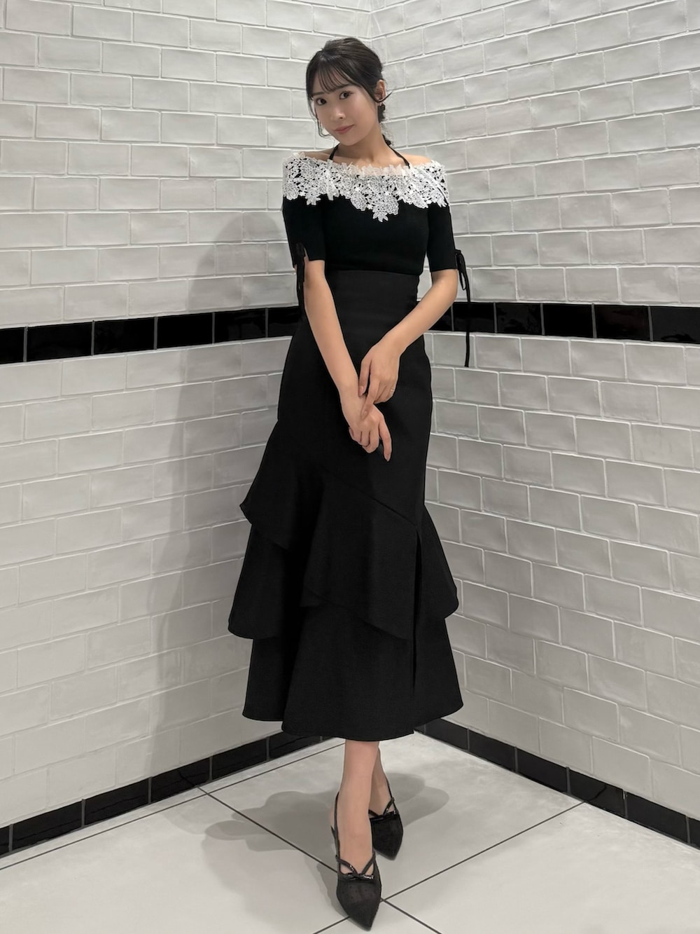 ブラック系のニット/セーター、ブラック系のスカート、ブラック系のパンプスを着用したレディースの春コーディネートの5枚目の写真