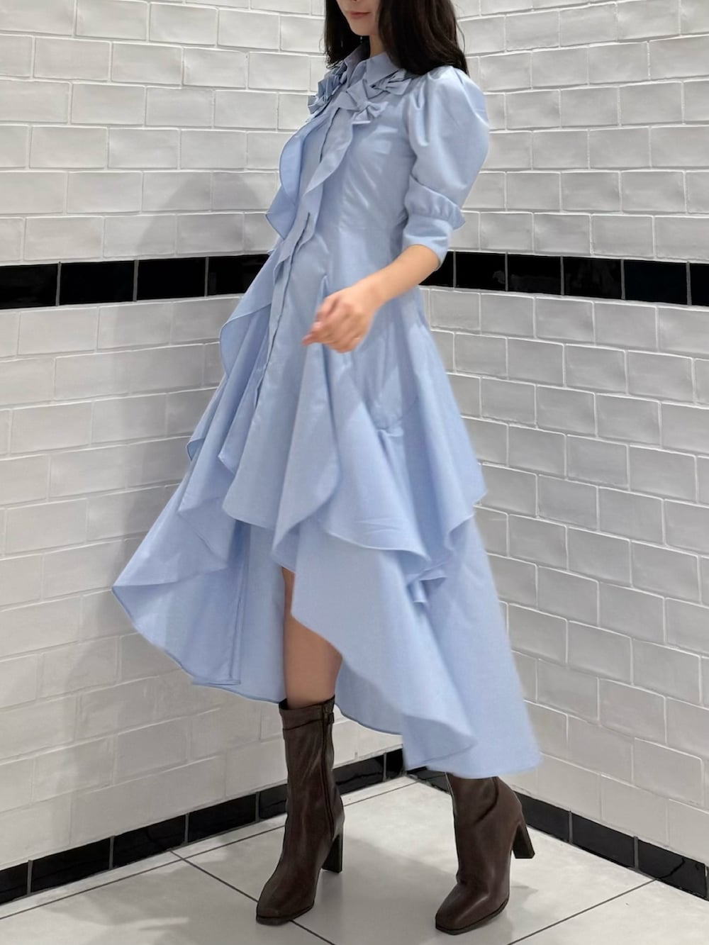 ブルー系のワンピース、ブラウン系のブーツを着用したレディースの春コーディネートの2枚目の写真