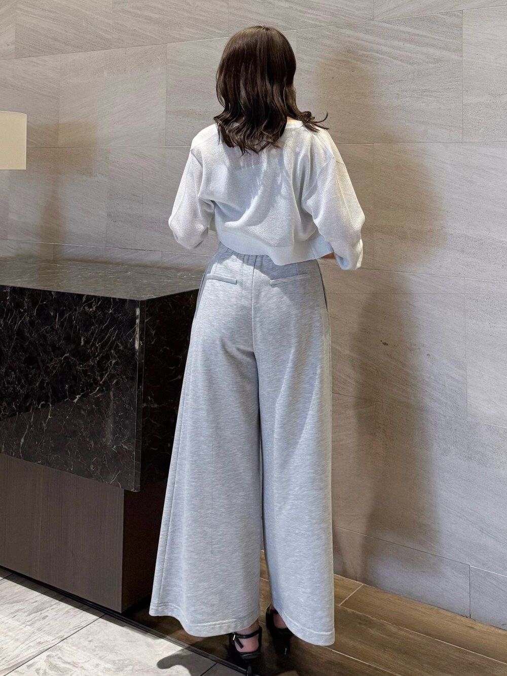 グレー系のニット/セーター、グレー系のその他パンツ、ブラック系のパンプスを着用したレディースの春コーディネートの4枚目の写真