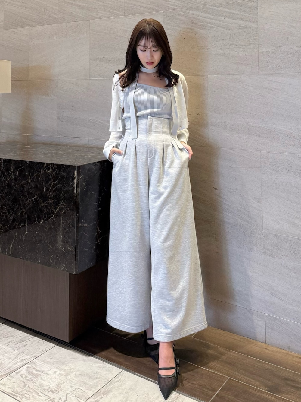 グレー系のニット/セーター、グレー系のその他パンツ、ブラック系のパンプスを着用したレディースの春コーディネートの2枚目の写真