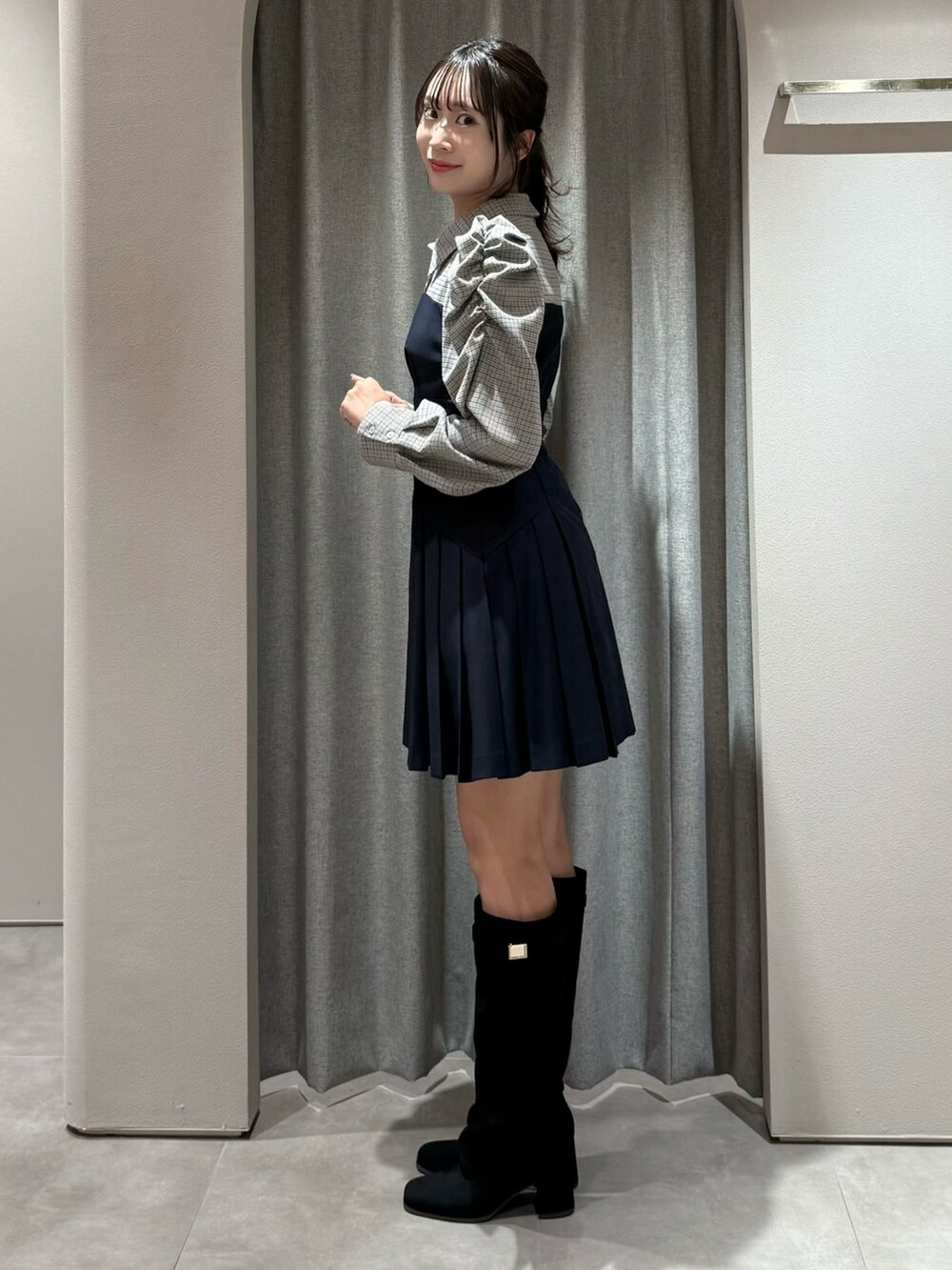 ブルー系のワンピース、ブラック系のブーツを着用したレディースの秋コーディネートの4枚目の写真