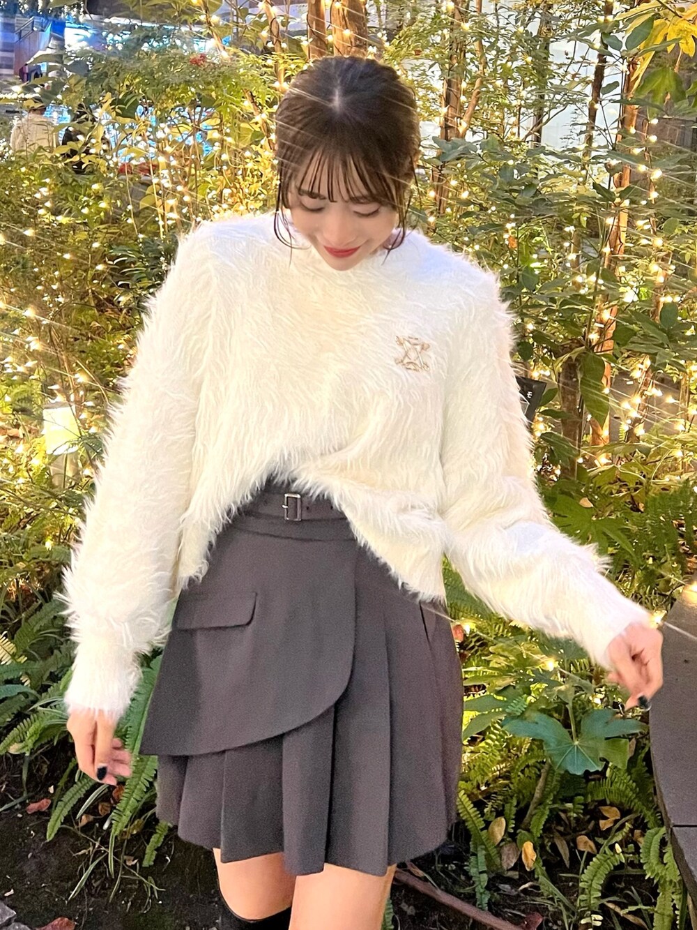 ホワイト系のニット/セーター、グレー系のスカート、ゴールド系のブローチ/コサージュを着用したレディースの冬コーディネートの2枚目の写真