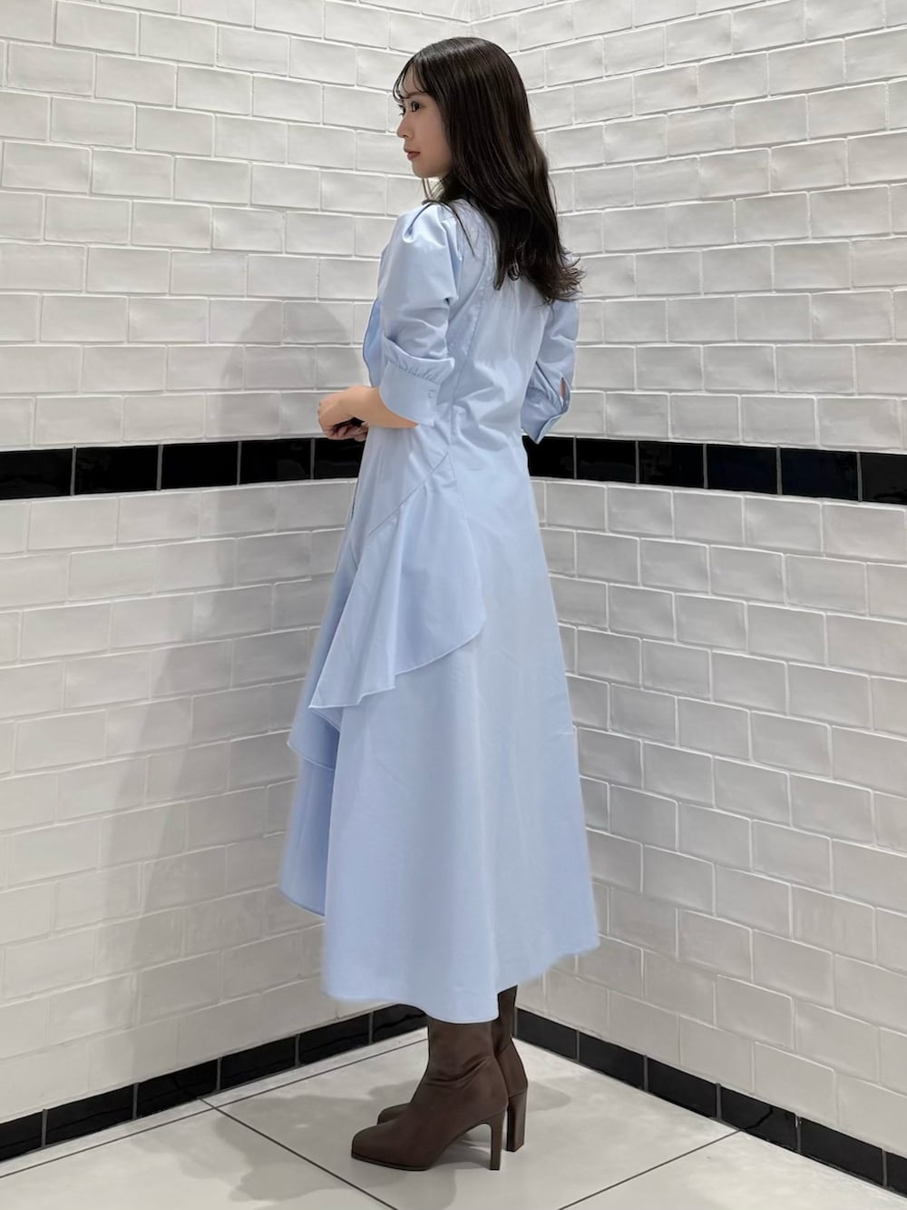 ブルー系のワンピース、ブラウン系のブーツを着用したレディースの春コーディネートの4枚目の写真