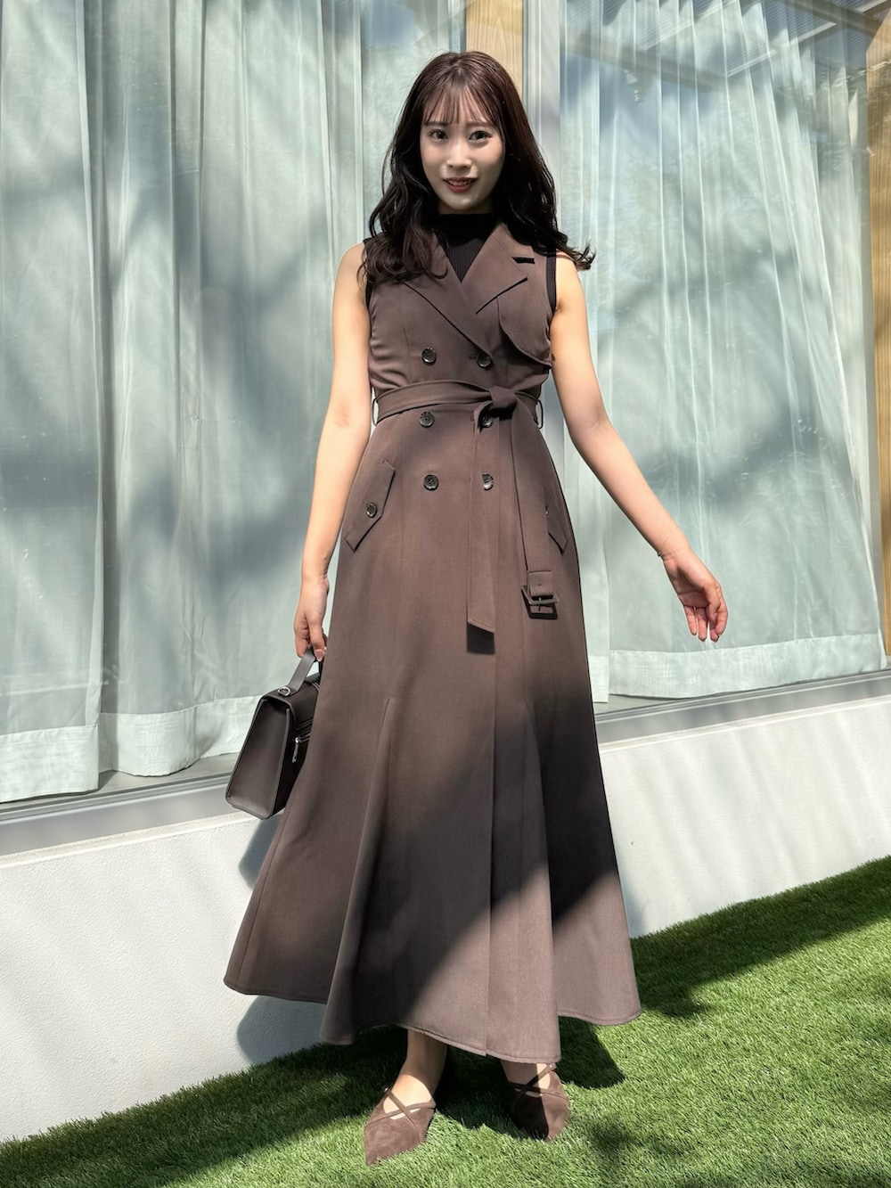 ブラウン系のワンピース、ブラウン系のショルダーバッグ、ブラウン系のパンプスを着用したレディースの秋コーディネートの2枚目の写真