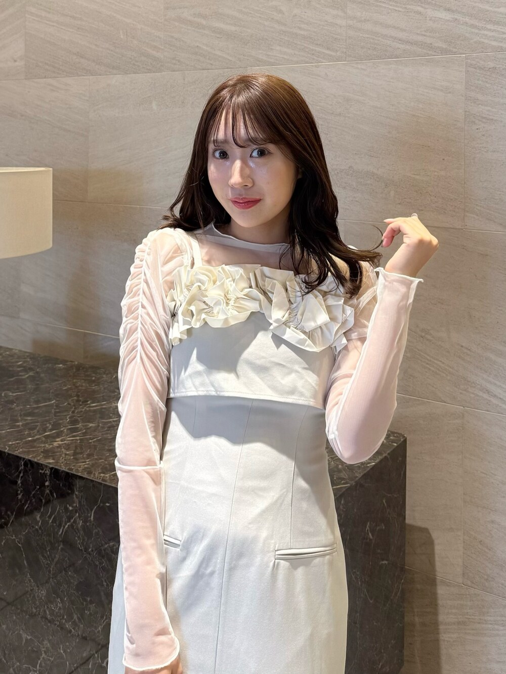 ベージュ系のワンピース、ホワイト系のTシャツ/カットソー、ブラウン系のローファーを着用したレディースの春コーディネートの6枚目の写真