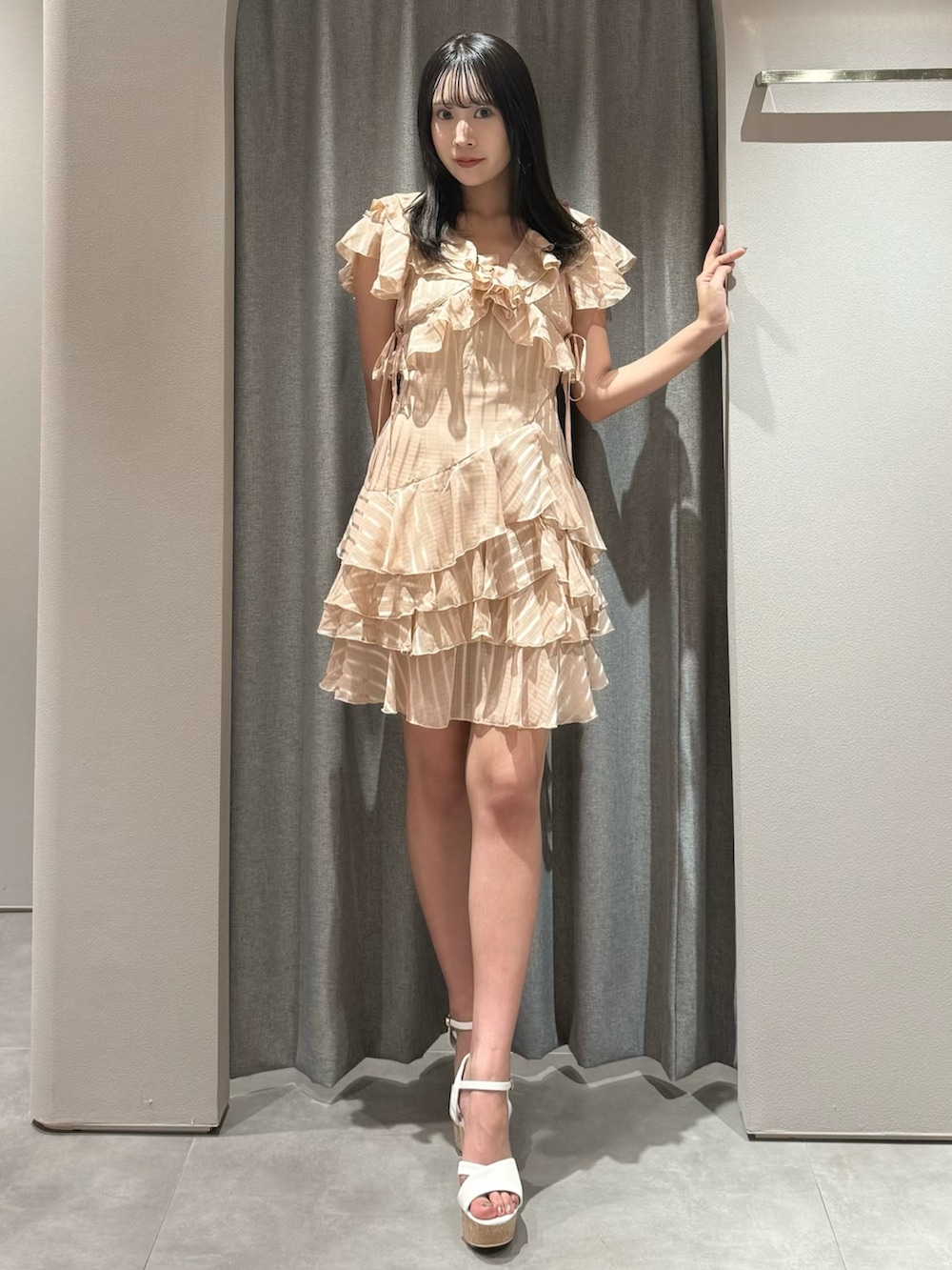 オレンジ系のワンピース、ホワイト系のサンダルを着用したレディースの夏コーディネートの2枚目の写真