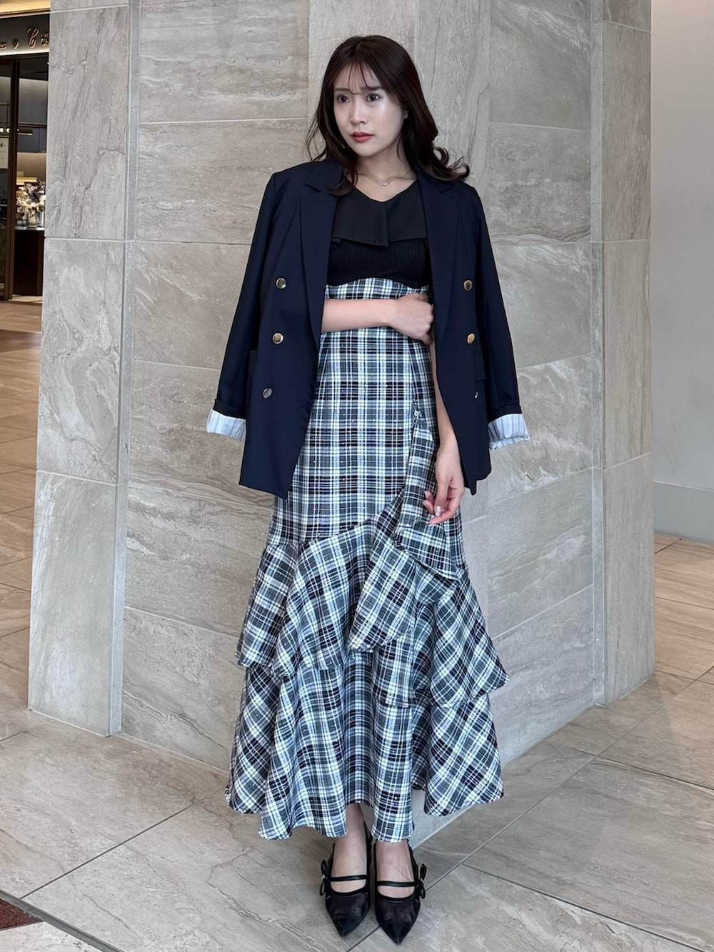 ブルー系のテーラードジャケット、ブラック系のワンピース、ブラック系のパンプスを着用したレディースの春コーディネートの3枚目の写真