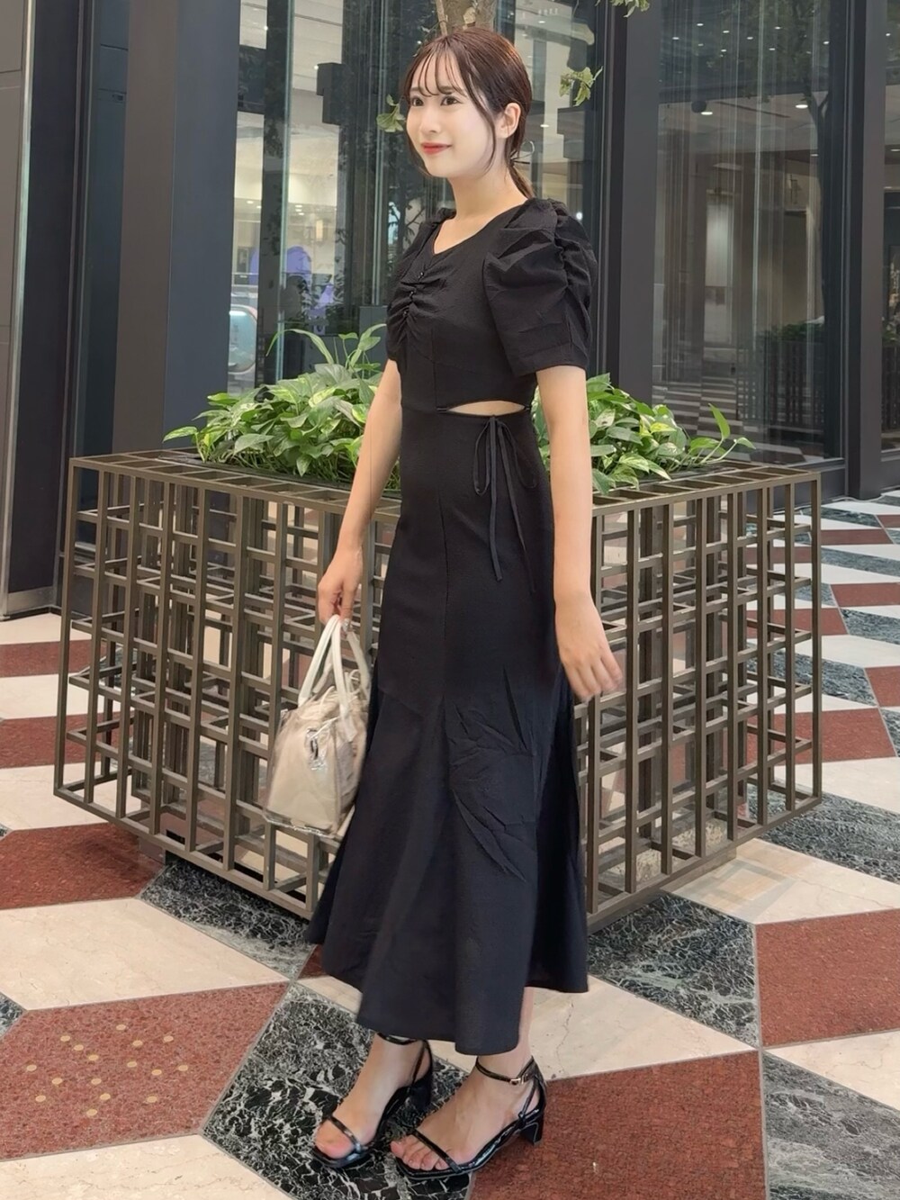 ブラック系のワンピース、ブラック系のサンダルを着用したレディースの夏コーディネートの5枚目の写真