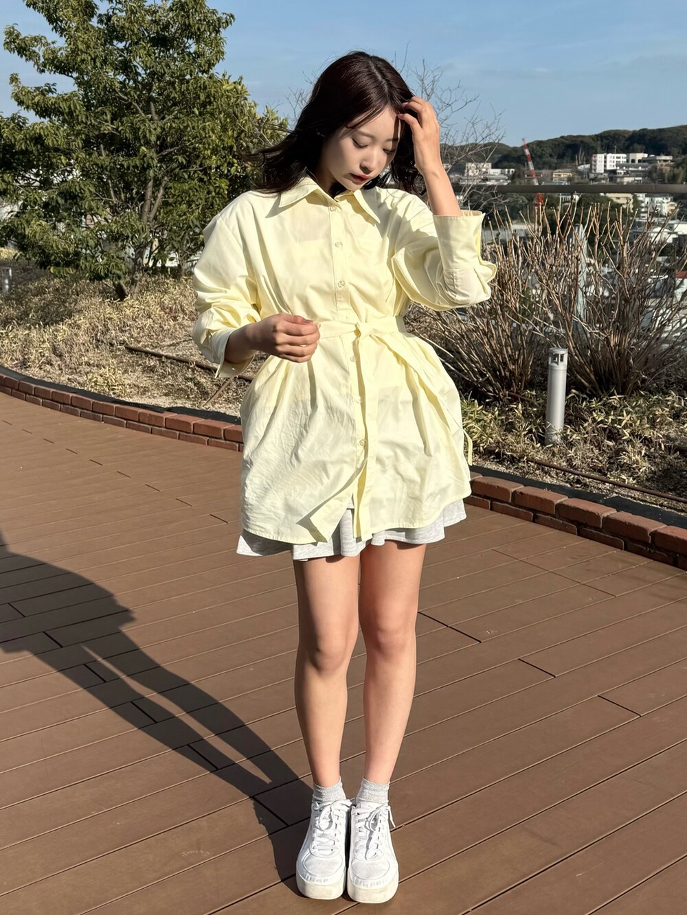 イエロー系のシャツ/ブラウス、グレー系のスカートを着用したレディースの春コーディネートの6枚目の写真