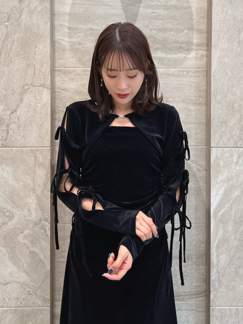 ブラック系のワンピース、ブラック系のパンプスを着用したレディースの冬コーディネートの6枚目の写真