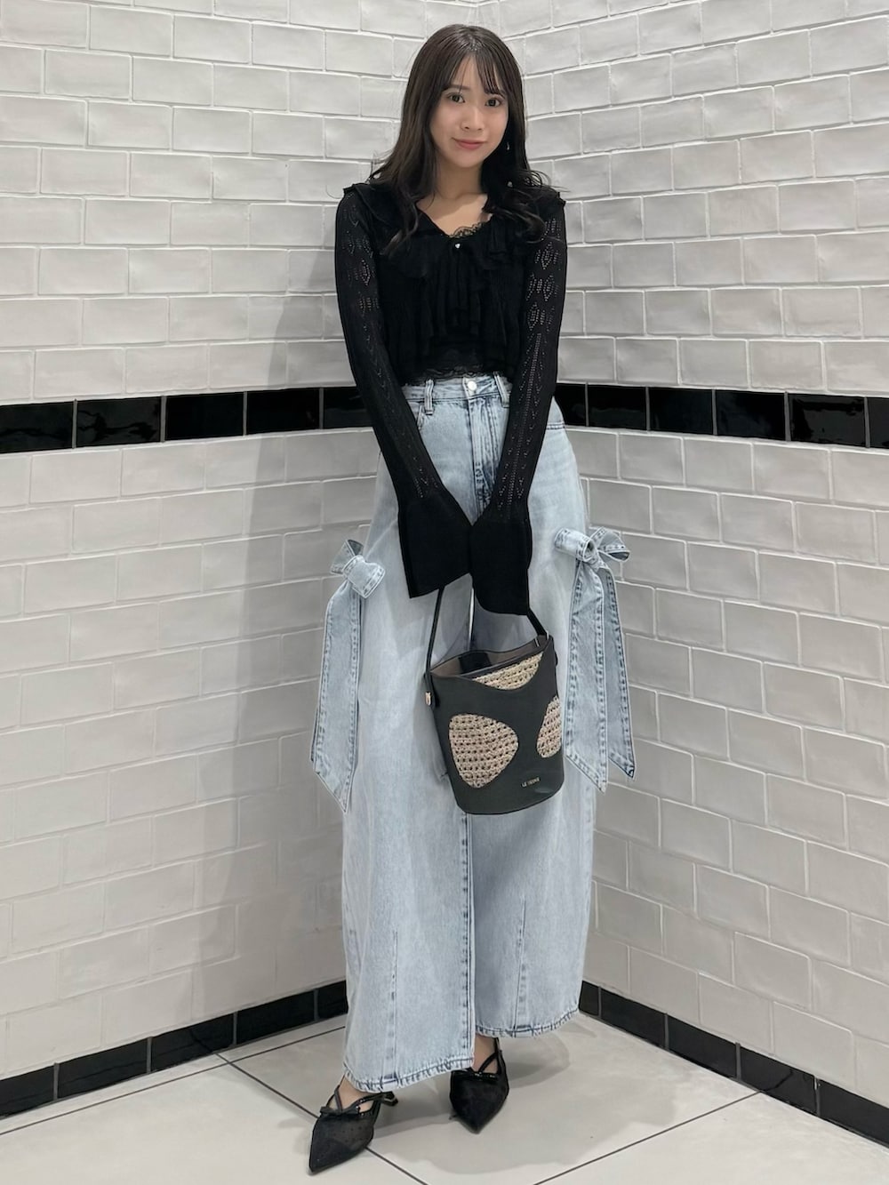 ブラック系のカーディガン/ボレロ、ブラック系のキャミソール、ブルー系のデニムパンツを着用したレディースの春コーディネートの2枚目の写真