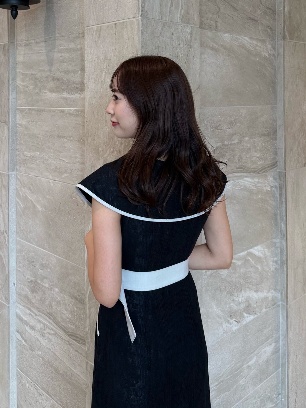 ブラック系のワンピース、ブラック系のパンプスを着用したレディースの夏コーディネートの8枚目の写真