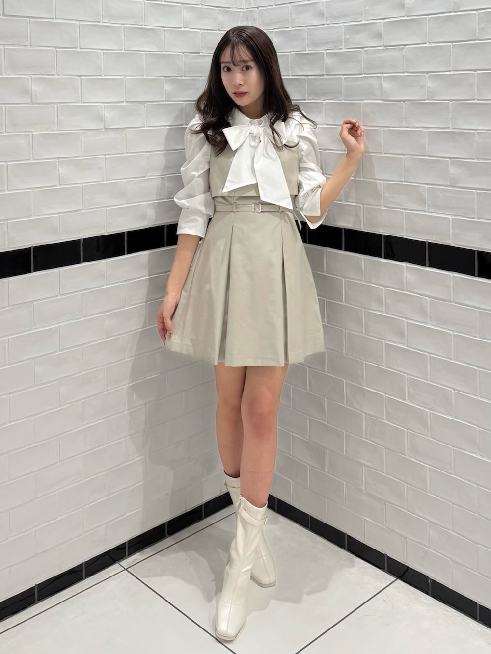 ベージュ系のワンピース、ホワイト系のブーツを着用したレディースの春コーディネートの5枚目の写真