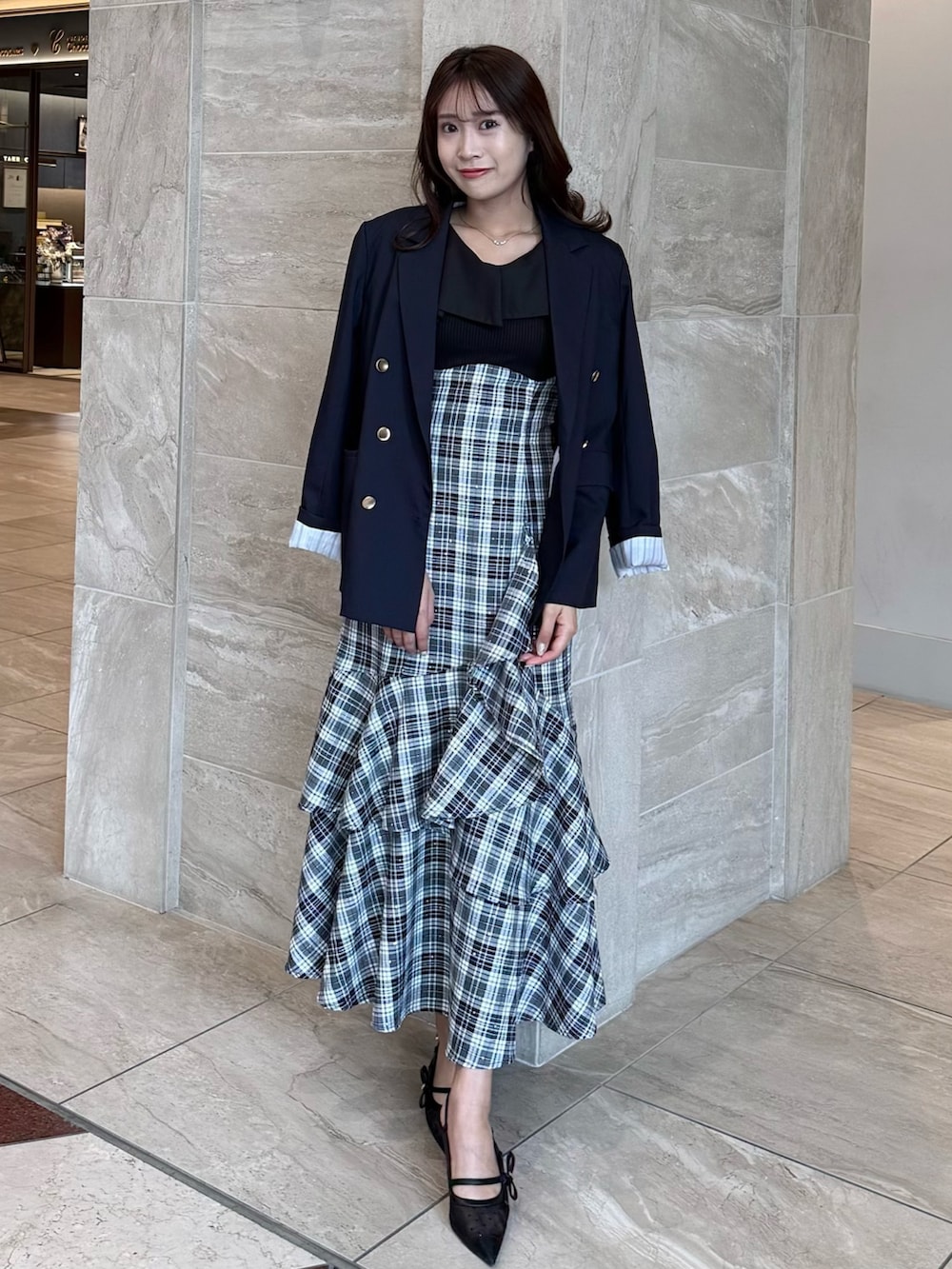 ブルー系のテーラードジャケット、ブラック系のワンピース、ブラック系のパンプスを着用したレディースの春コーディネートの2枚目の写真