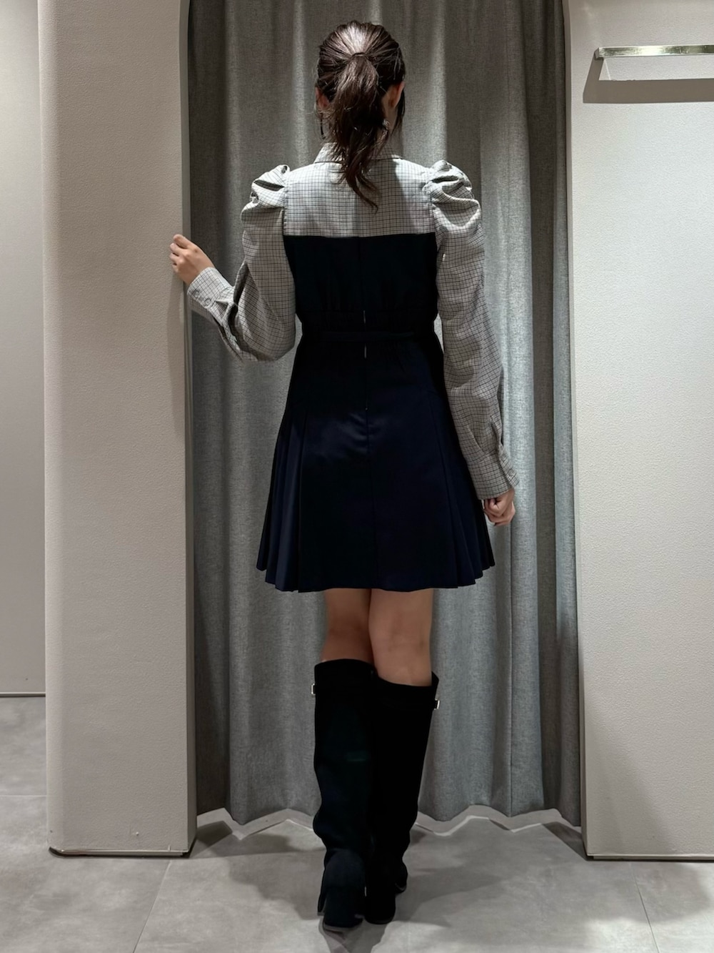 ブルー系のワンピース、ブラック系のブーツを着用したレディースの秋コーディネートの5枚目の写真