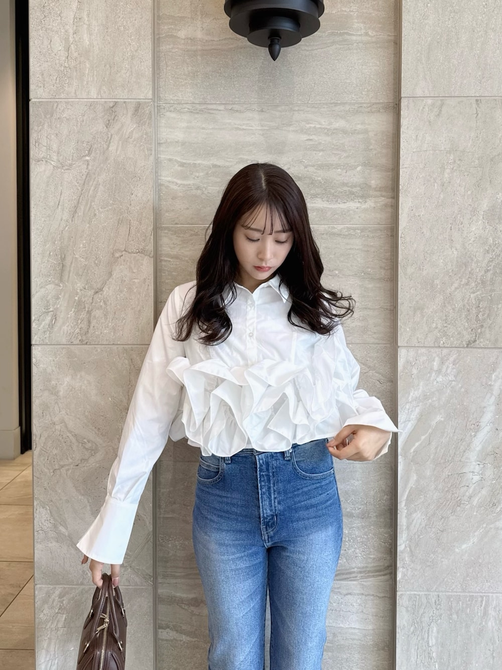 ホワイト系のシャツ/ブラウス、ブルー系のデニムパンツ、ホワイト系のパンプスを着用したレディースの春コーディネートの7枚目の写真