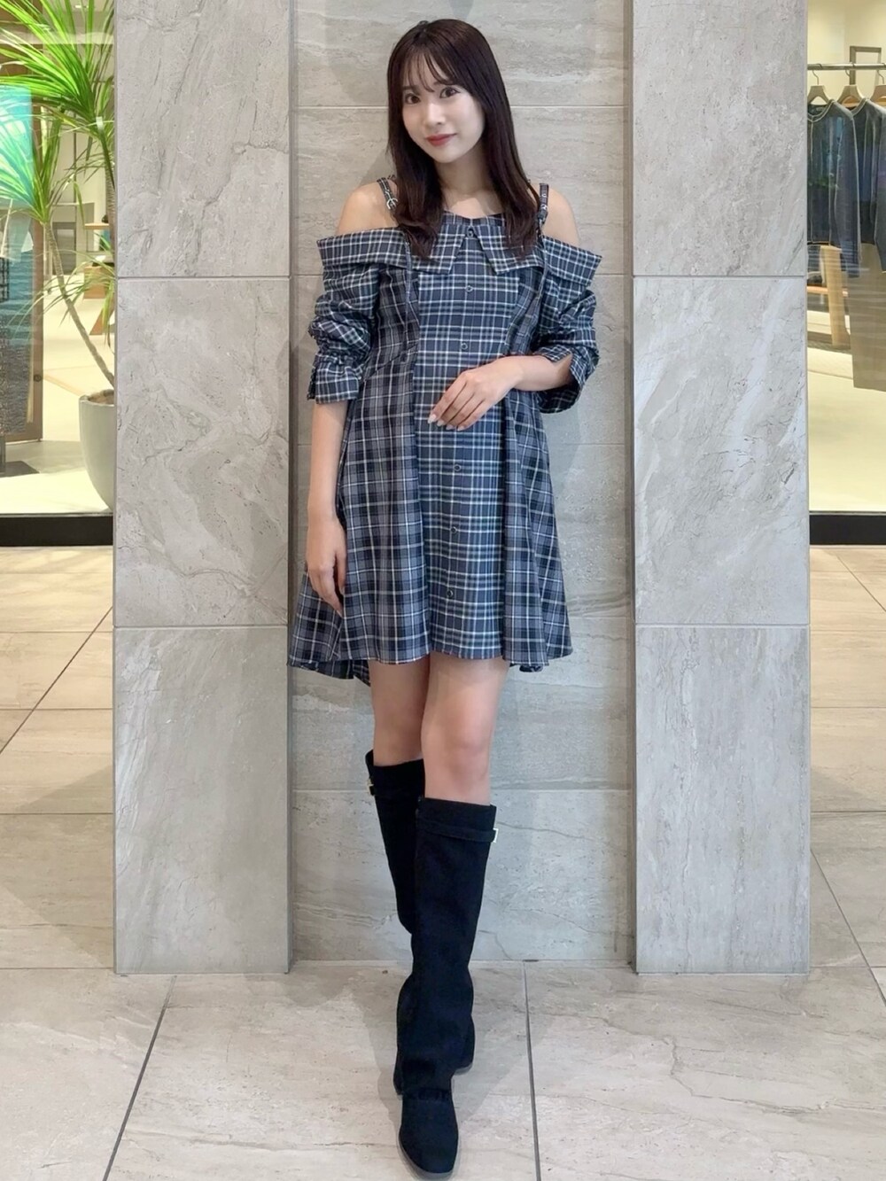 ブルー系のワンピース、ブラック系のブーツを着用したレディースの秋コーディネートの2枚目の写真