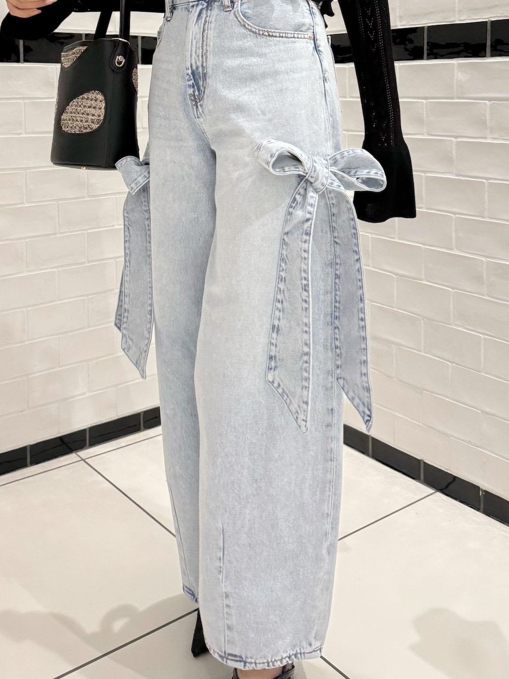 ブラック系のカーディガン/ボレロ、ブラック系のキャミソール、ブルー系のデニムパンツを着用したレディースの春コーディネートの7枚目の写真