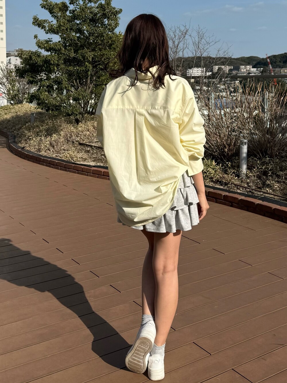 イエロー系のシャツ/ブラウス、グレー系のスカートを着用したレディースの春コーディネートの2枚目の写真