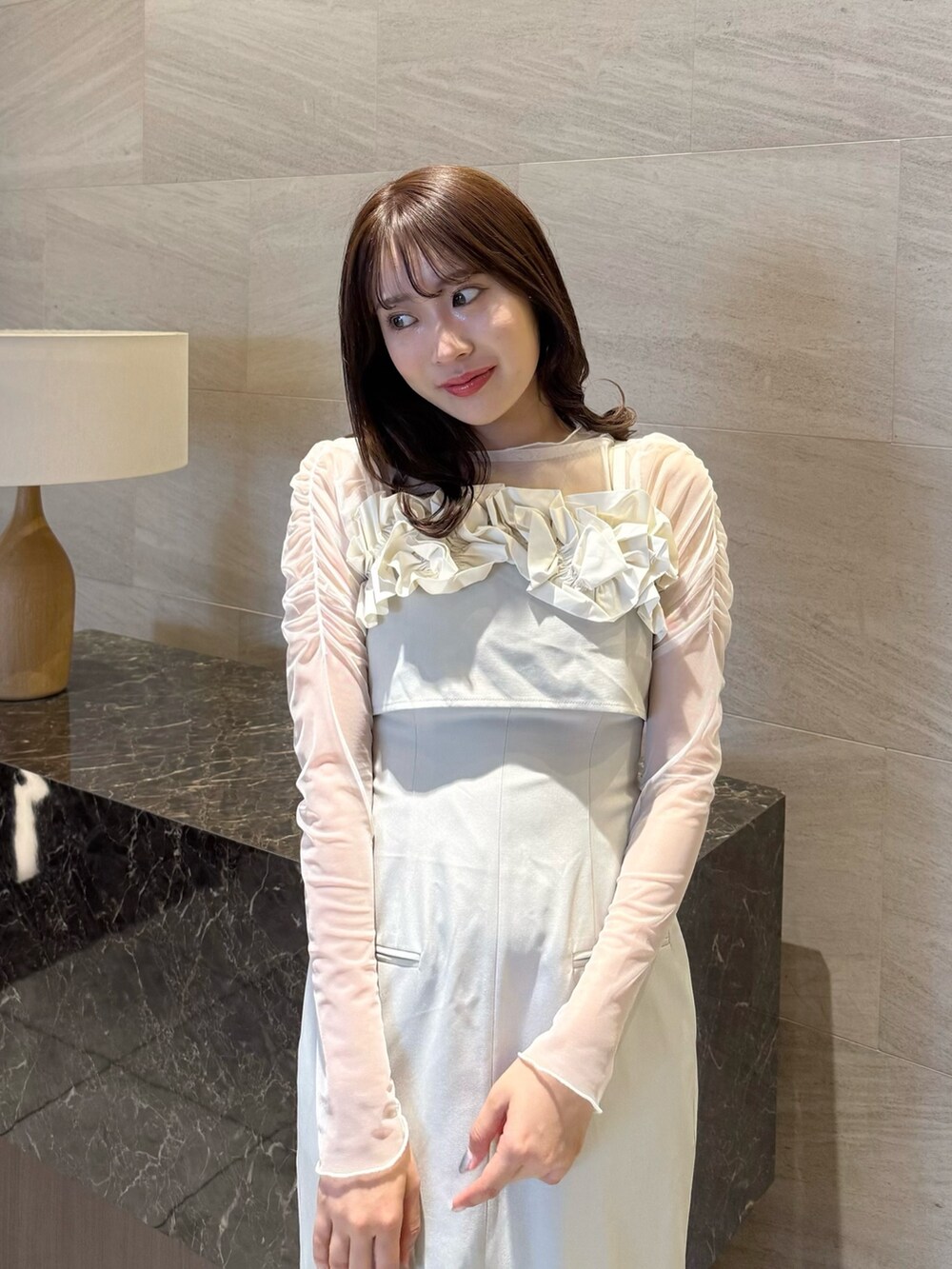 ベージュ系のワンピース、ホワイト系のTシャツ/カットソー、ブラウン系のローファーを着用したレディースの春コーディネートの8枚目の写真