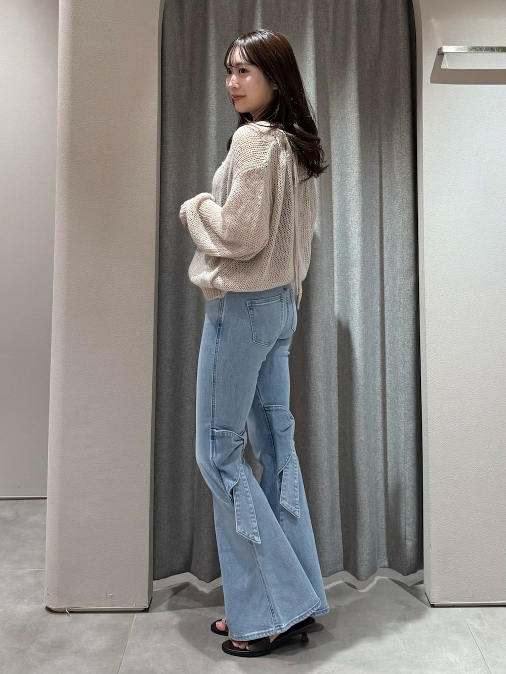 ピンク系のニット/セーター、ブルー系のデニムパンツ、ブラウン系のサンダルを着用したレディースの冬コーディネートの4枚目の写真