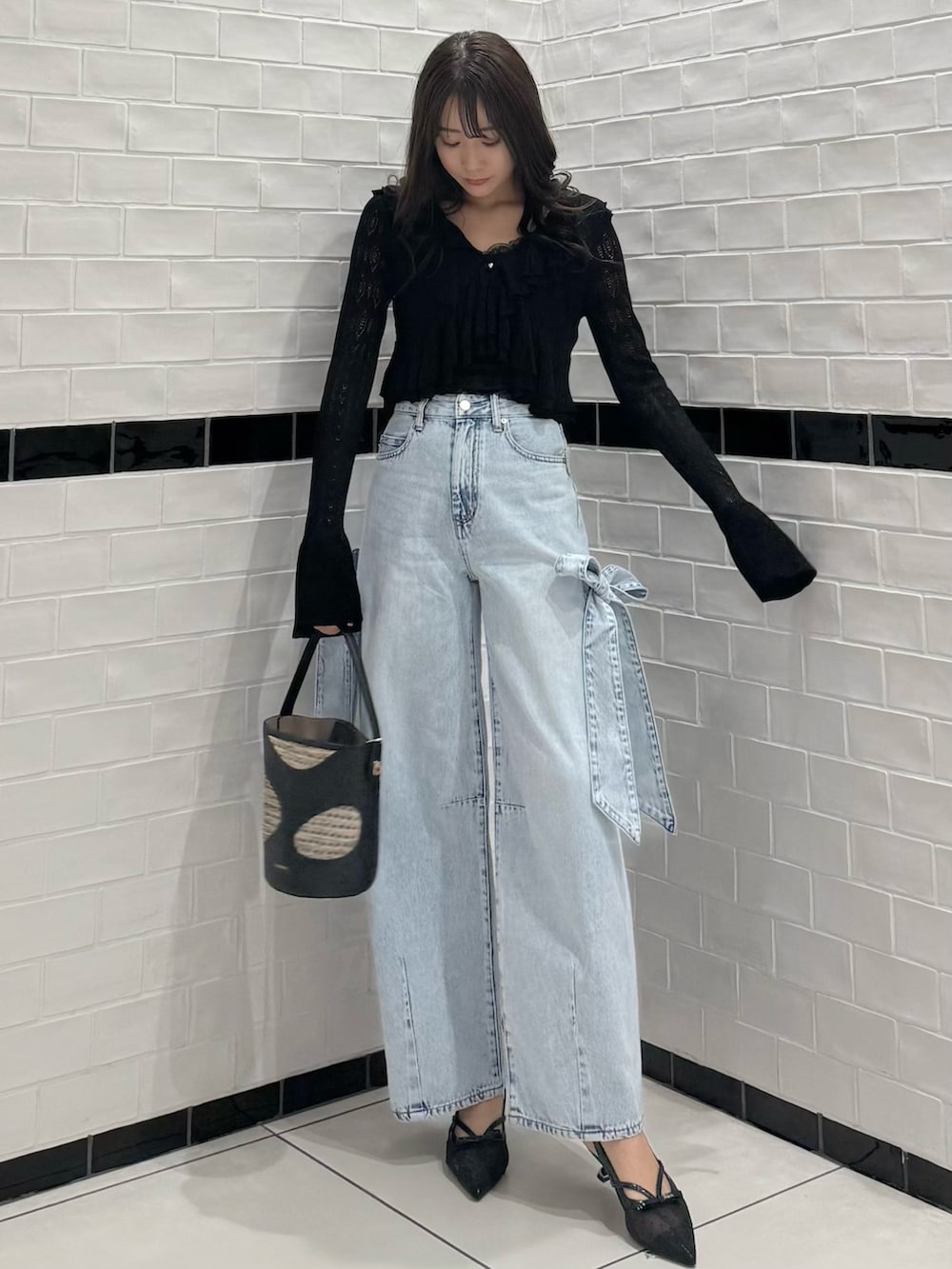 ブラック系のカーディガン/ボレロ、ブラック系のキャミソール、ブルー系のデニムパンツを着用したレディースの春コーディネートの3枚目の写真