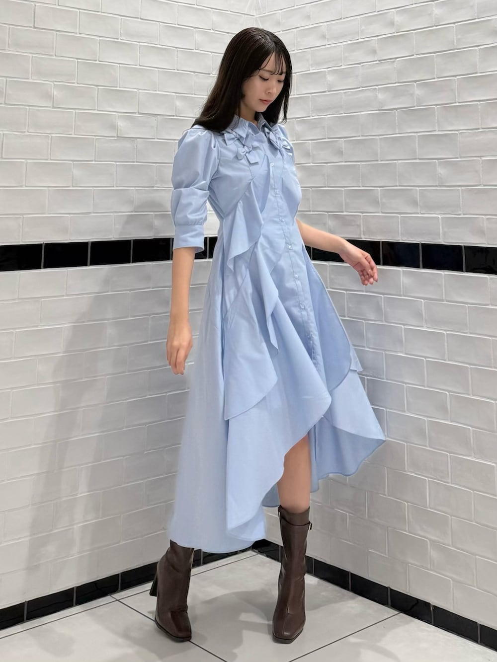 ブルー系のワンピース、ブラウン系のブーツを着用したレディースの春コーディネートの3枚目の写真