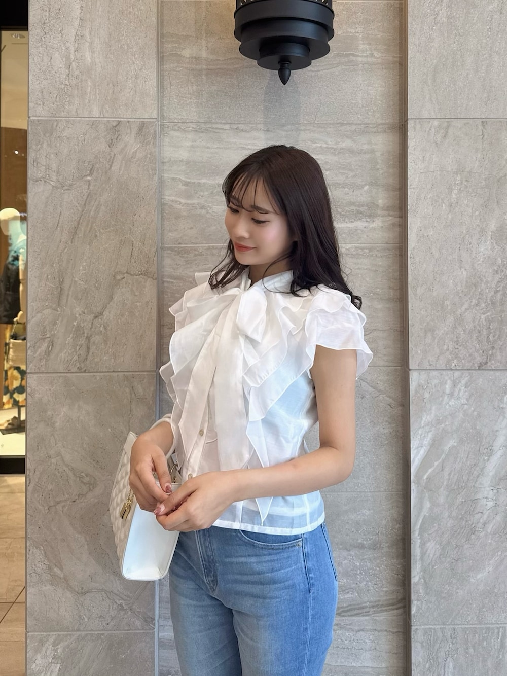 ホワイト系のシャツ/ブラウス、ブルー系のデニムパンツ、ホワイト系のサンダルを着用したレディースの春コーディネートの8枚目の写真