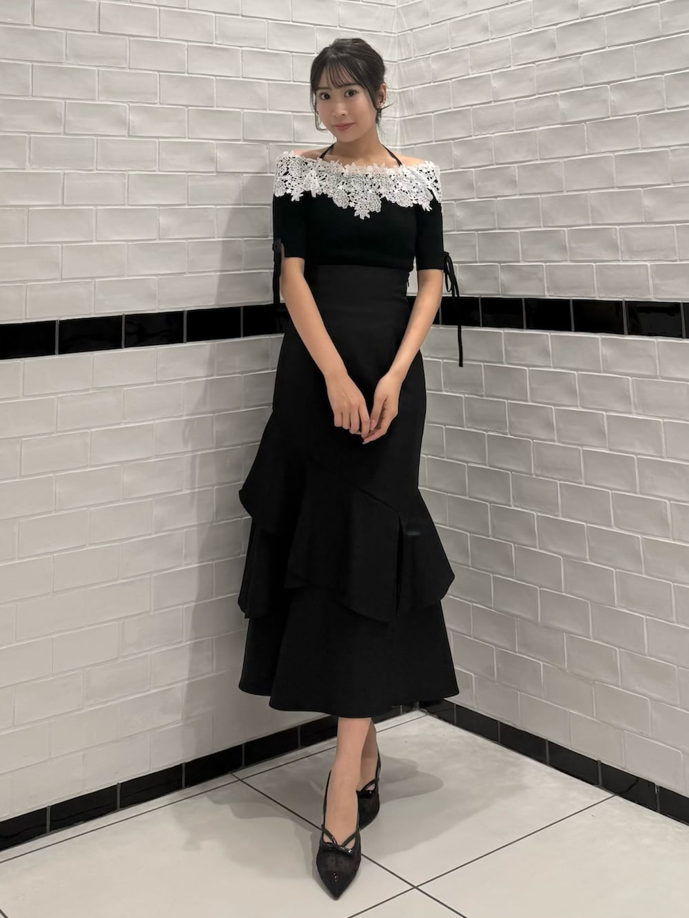 ブラック系のニット/セーター、ブラック系のスカート、ブラック系のパンプスを着用したレディースの春コーディネートの4枚目の写真