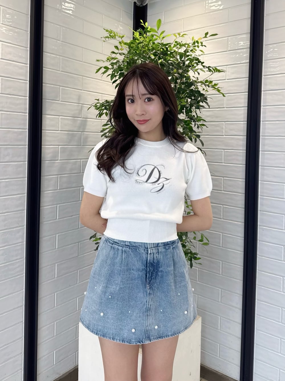 ホワイト系のニット/セーター、ブルー系のデニムパンツ、ホワイト系のブーツを着用したレディースの春コーディネートの9枚目の写真