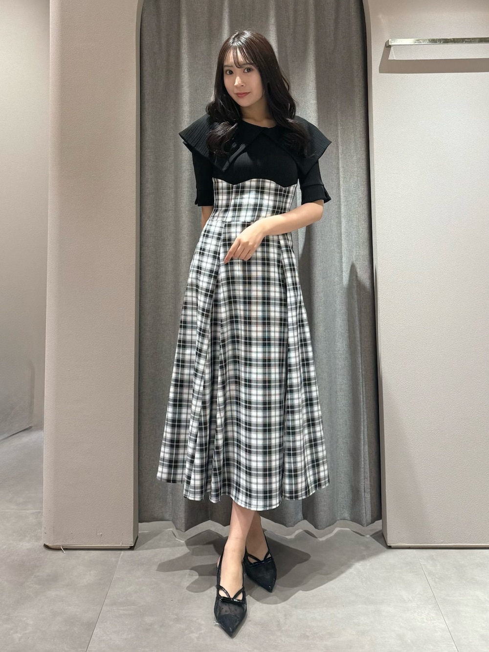 ブラック系のワンピース、ブラック系のパンプスを着用したレディースの春コーディネートの2枚目の写真