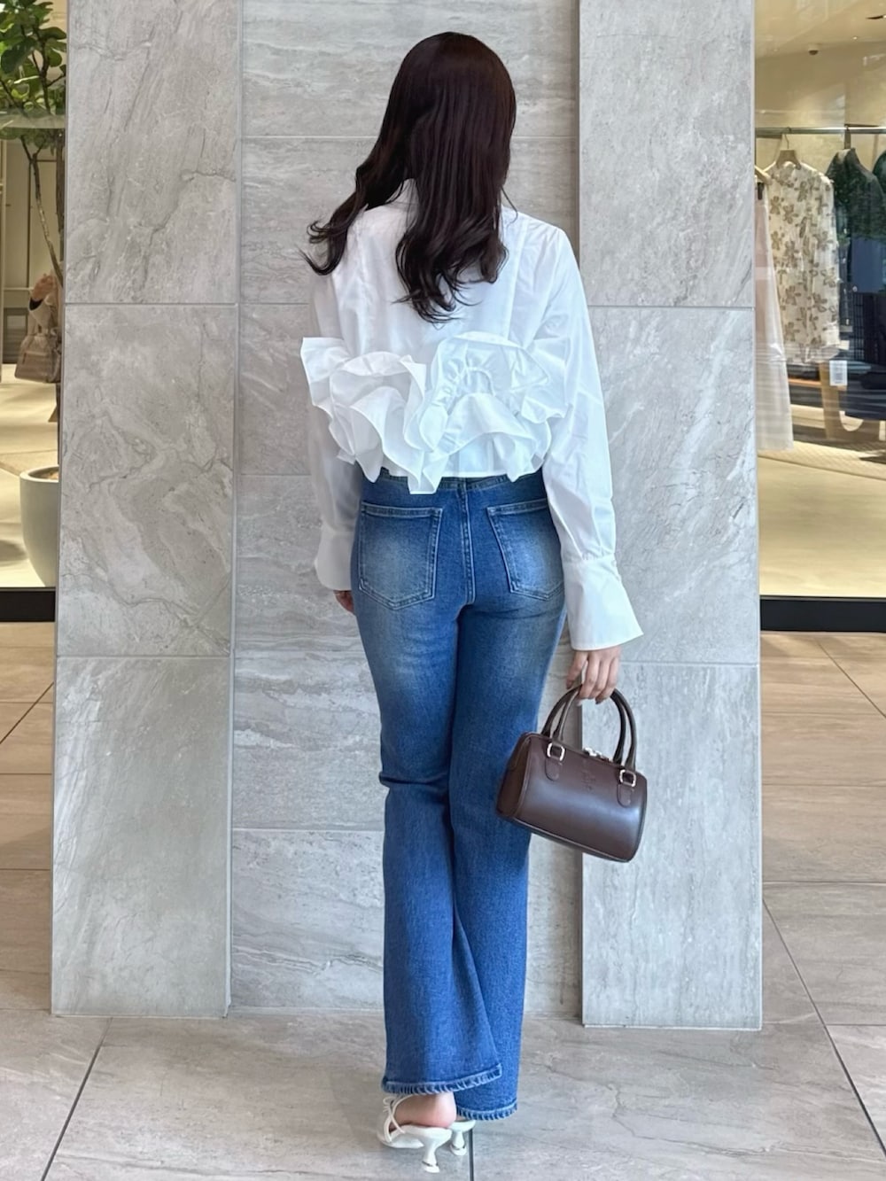 ホワイト系のシャツ/ブラウス、ブルー系のデニムパンツ、ホワイト系のパンプスを着用したレディースの春コーディネートの5枚目の写真