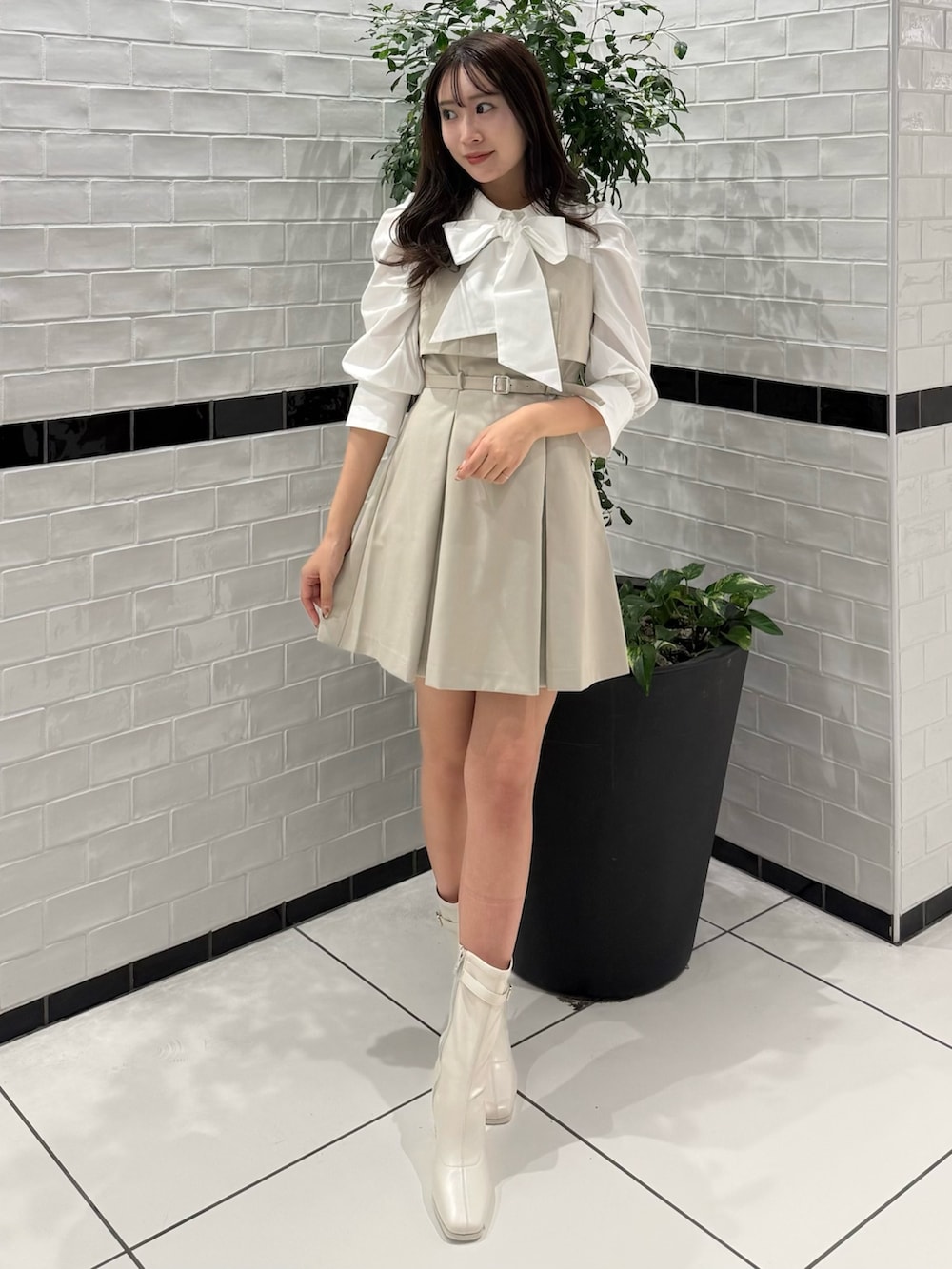 ベージュ系のワンピース、ホワイト系のブーツを着用したレディースの春コーディネートの2枚目の写真