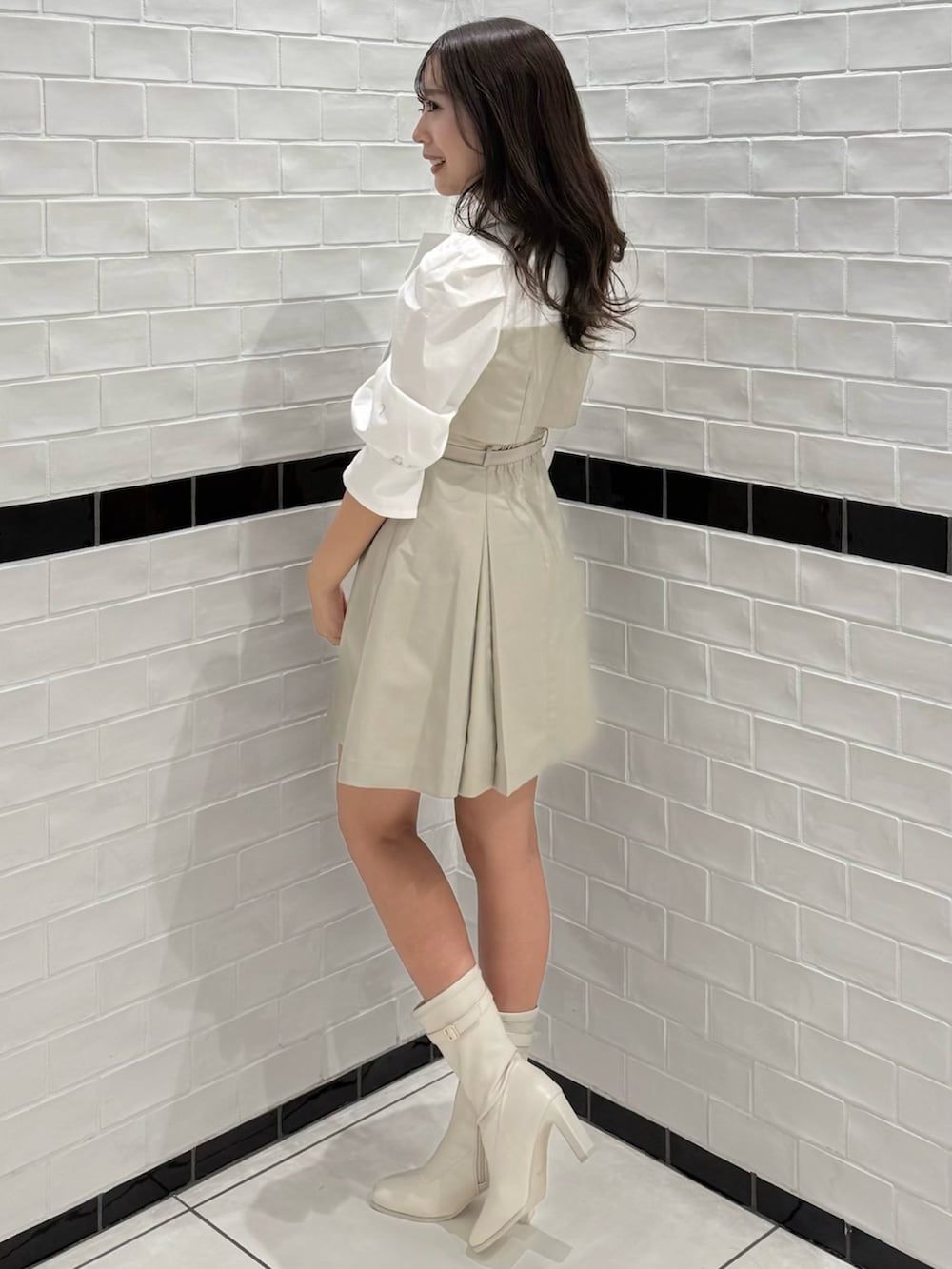 ベージュ系のワンピース、ホワイト系のブーツを着用したレディースの春コーディネートの6枚目の写真