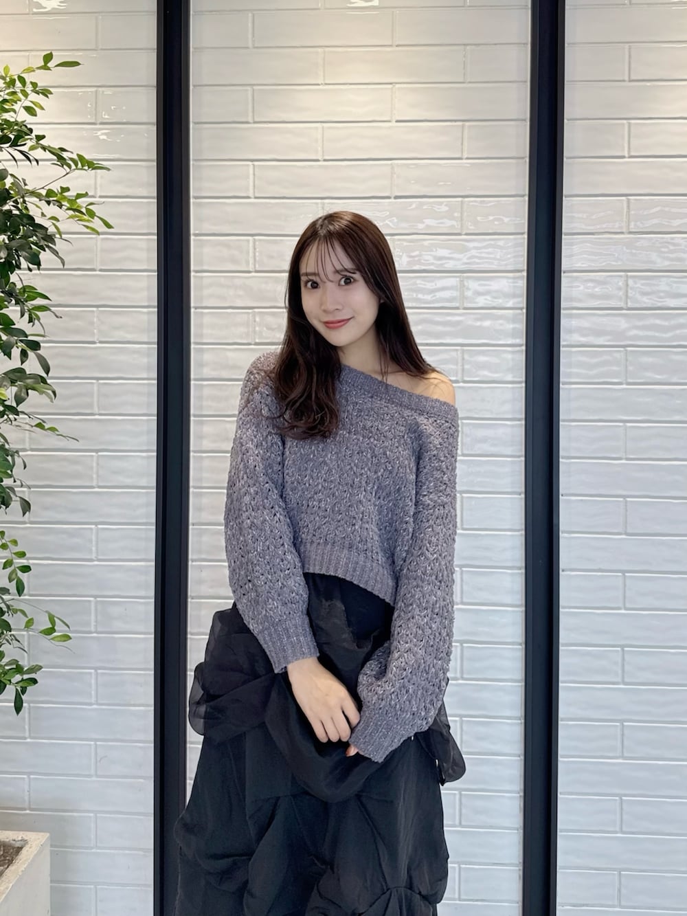 グレー系のニット/セーター、ブラック系のスカート、ブラック系のブーツを着用したレディースの冬コーディネートの5枚目の写真