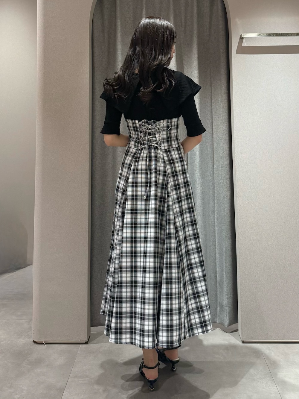 ブラック系のワンピース、ブラック系のパンプスを着用したレディースの春コーディネートの6枚目の写真