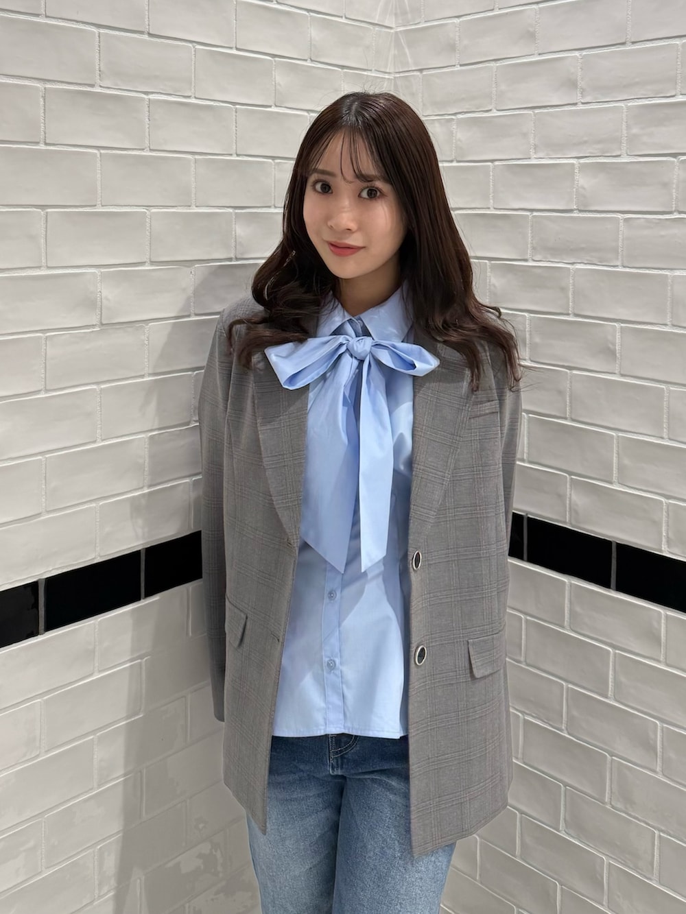 グレー系のテーラードジャケット、ブルー系のデニムパンツ、ブラウン系のブーツを着用したレディースの冬コーディネートの6枚目の写真