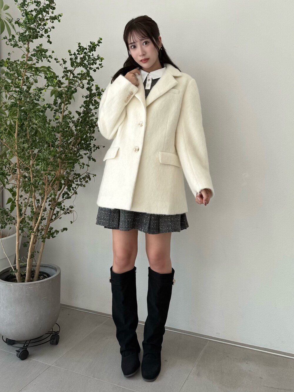 ホワイト系のテーラードジャケット、グレー系のワンピース、ブラック系のブーツを着用したレディースの秋コーディネートの2枚目の写真