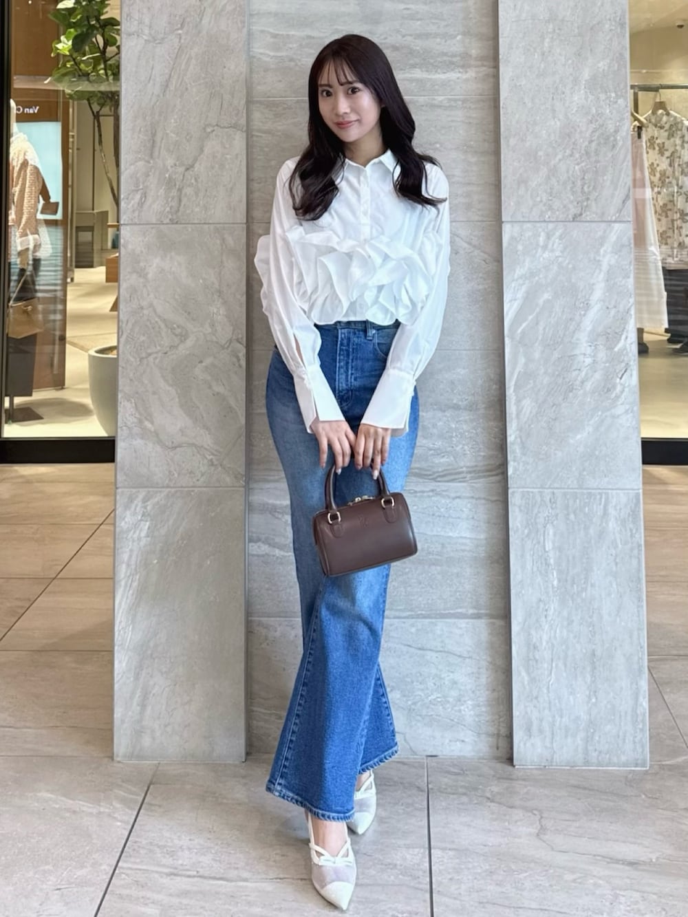 ホワイト系のシャツ/ブラウス、ブルー系のデニムパンツ、ホワイト系のパンプスを着用したレディースの春コーディネートの2枚目の写真