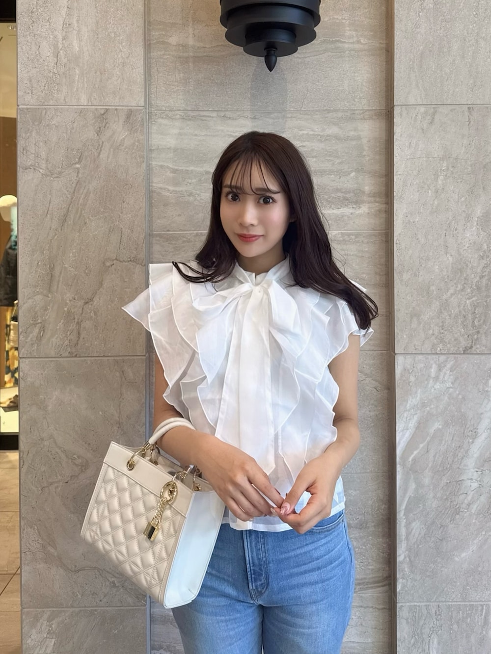 ホワイト系のシャツ/ブラウス、ブルー系のデニムパンツ、ホワイト系のサンダルを着用したレディースの春コーディネートの5枚目の写真