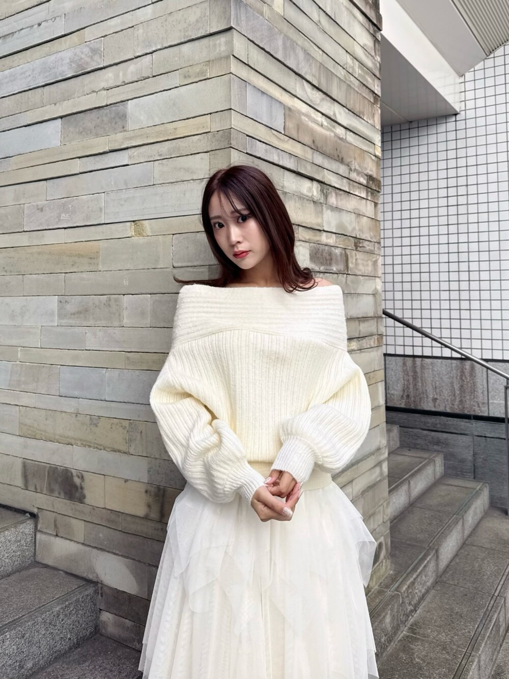 ブラウン系のパンプス、ホワイト系のニット/セーター、ホワイト系のスカートを着用したレディースの冬コーディネートの6枚目の写真