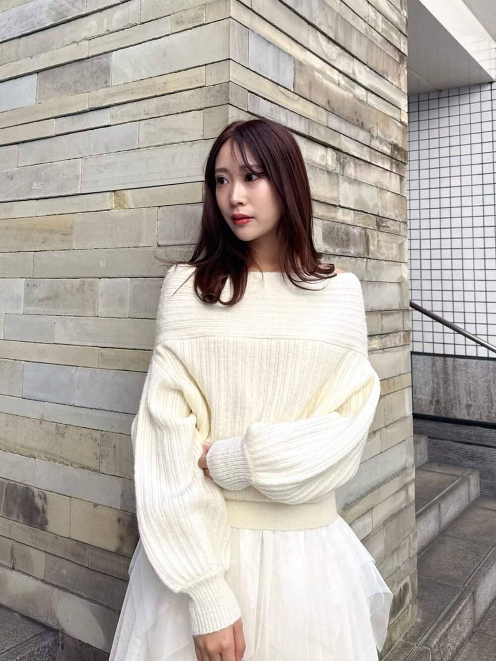 ブラウン系のパンプス、ホワイト系のニット/セーター、ホワイト系のスカートを着用したレディースの冬コーディネートの5枚目の写真