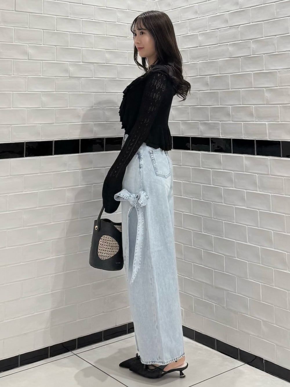 ブラック系のカーディガン/ボレロ、ブラック系のキャミソール、ブルー系のデニムパンツを着用したレディースの春コーディネートの4枚目の写真