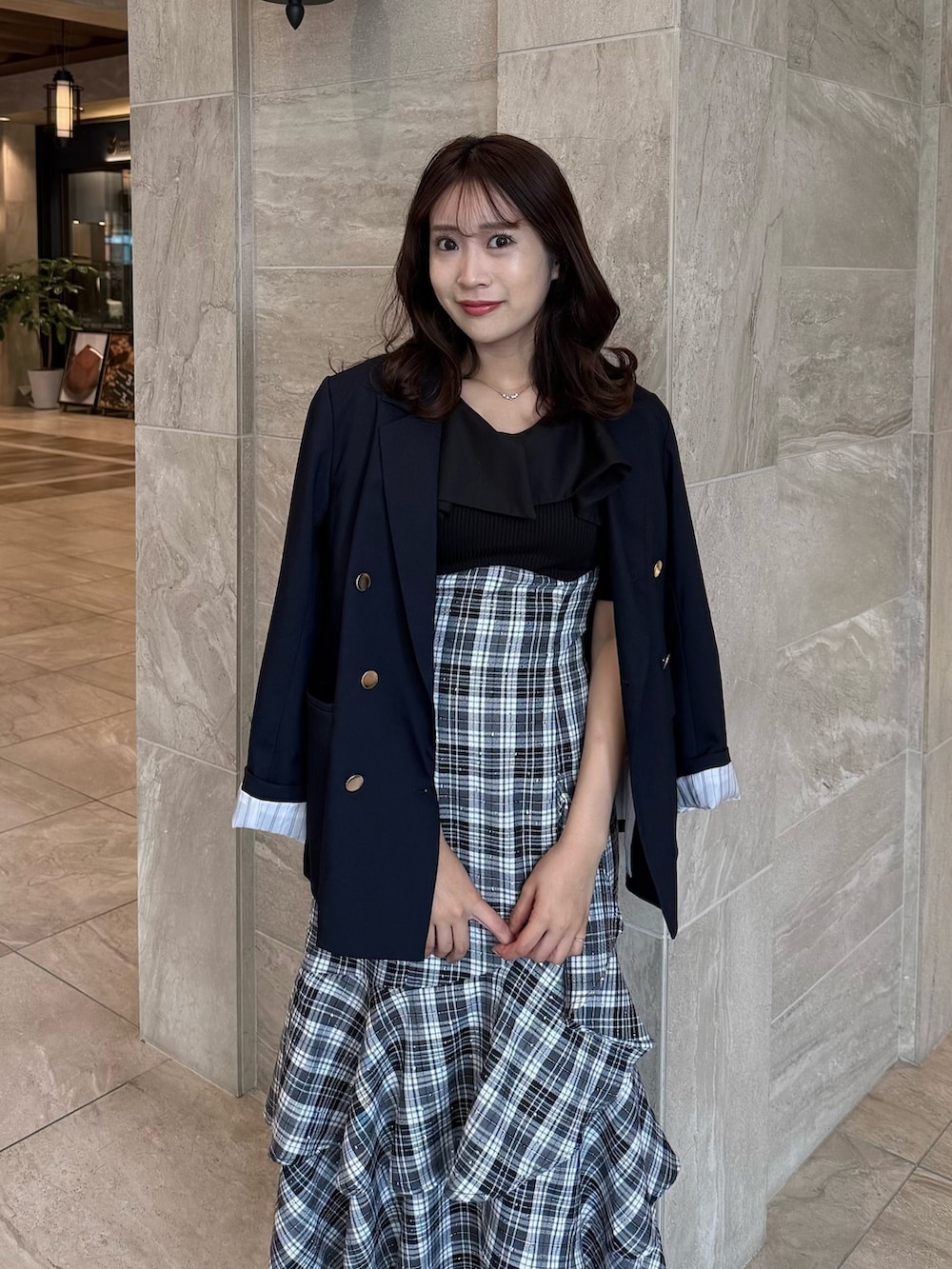 ブルー系のテーラードジャケット、ブラック系のワンピース、ブラック系のパンプスを着用したレディースの春コーディネートの5枚目の写真